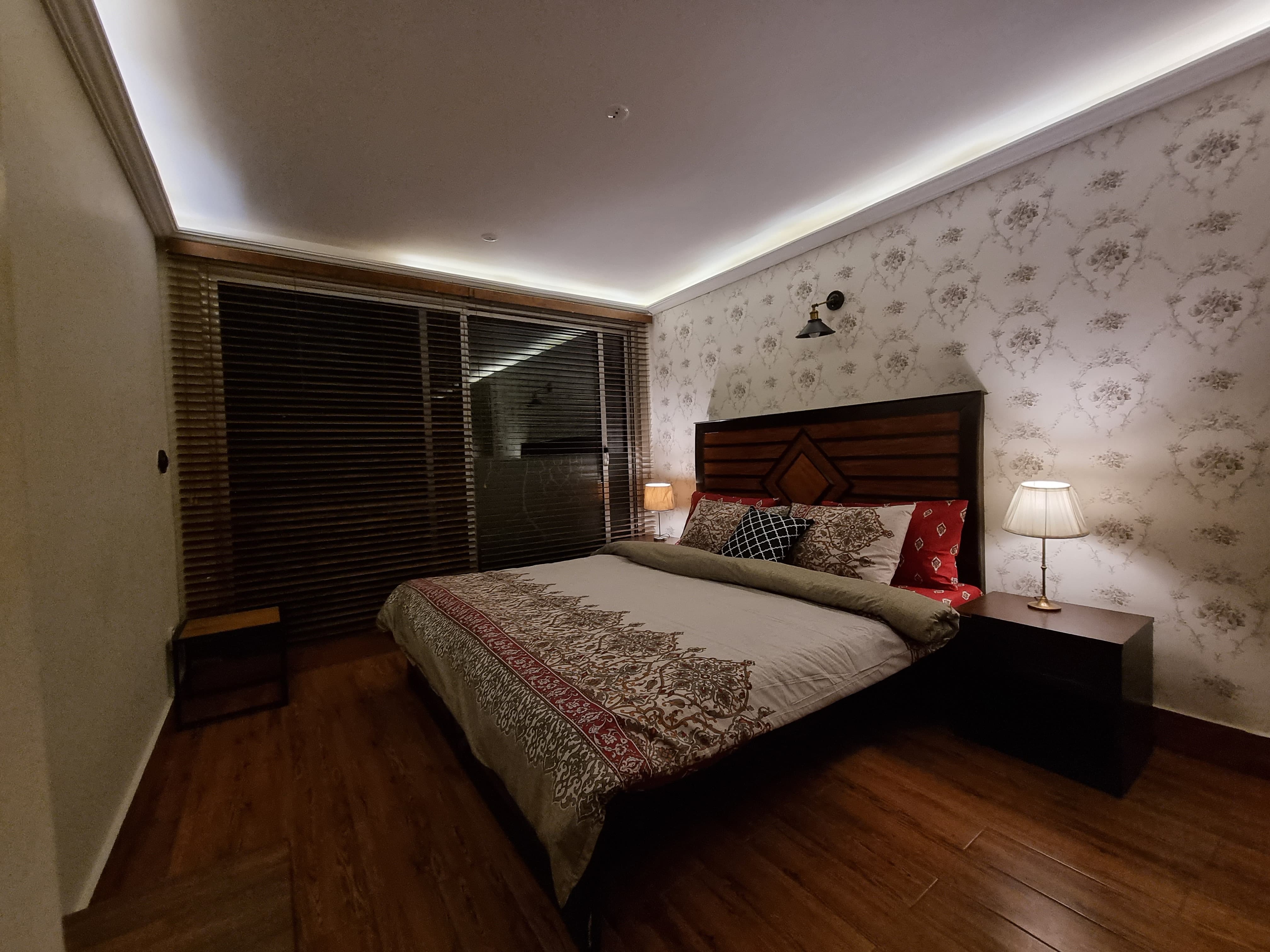 luxury cottage master bedroom with king bed, mountain view through large windows, elegant interior design, warm lighting